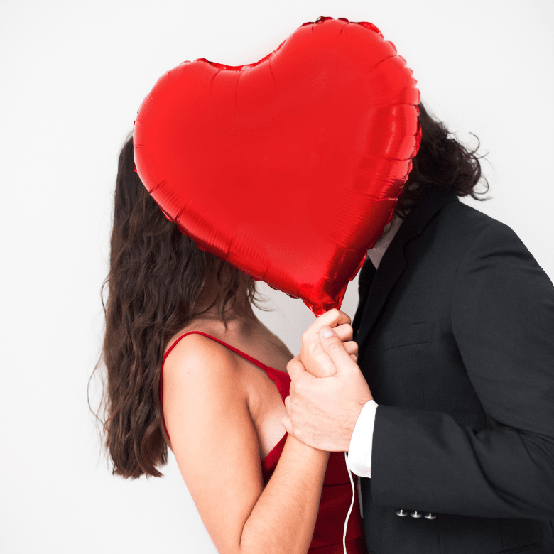 How to Indentify Financial Abuse in your relationship | couple standing closely together with a red heart-shaped balloon